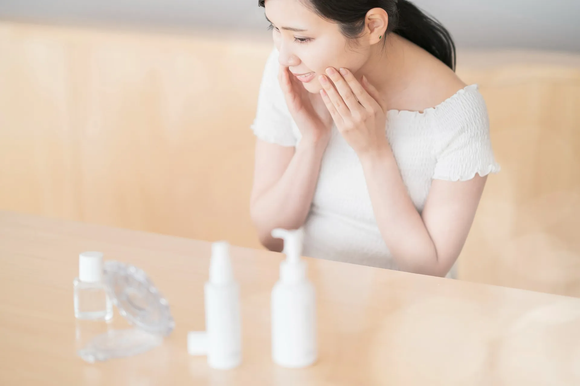 年齢を重ねて肌悩みが増えてしまい、鏡を見て落ち込む中年女性